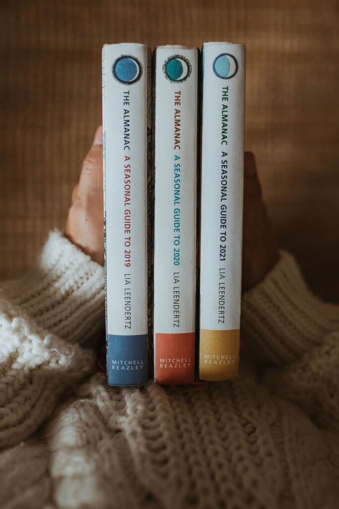 Hands holding a stack of seasonal almanacs