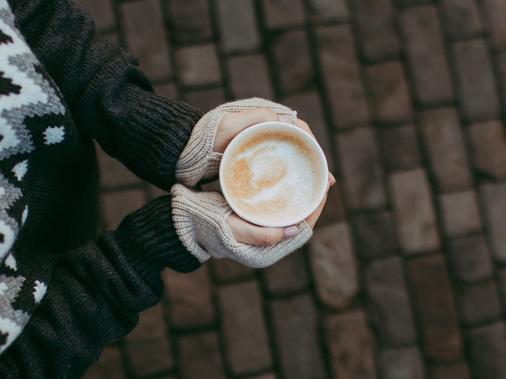Woman holding a cup of hot coffee in winter
